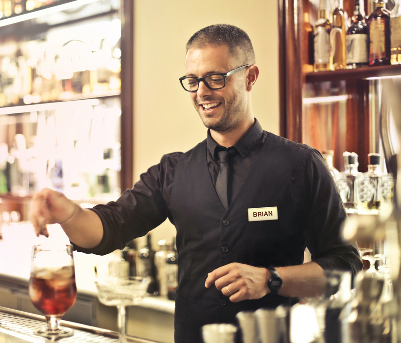 Bar tender wearing a domed polished gold name badge